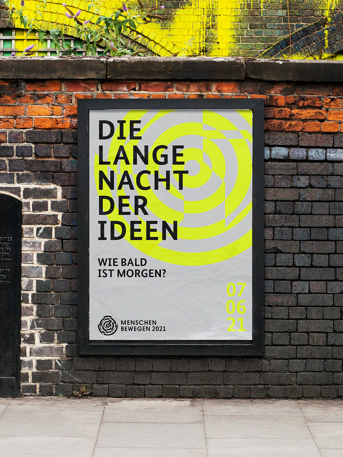 Menschen Bewegen 2021 Event Corporate Design graues Poster mit gelbem Keyvisual und schwarzer Schrift Lange Nach der Ideen im Rahmen an Backsteinmauer